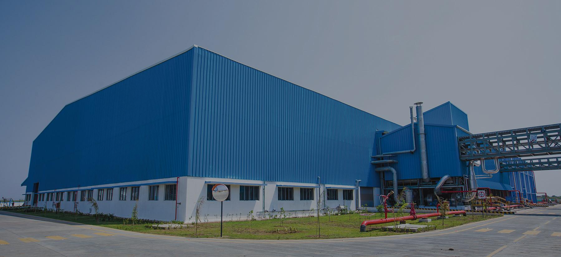 A large industrial building clad in blue steel roofing and walling sheets